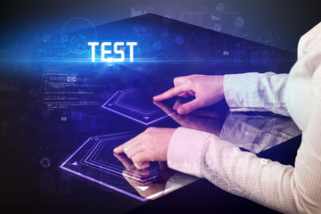 Hand touching digital table with TEST inscription, new age security concept