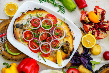 hot smoked fish koktal, Kazakh dish, with vegetables, tomatoes and onions on a festive table, special dish