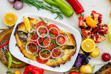 hot smoked fish koktal, Kazakh dish, with vegetables, tomatoes and onions on a festive table, special dish