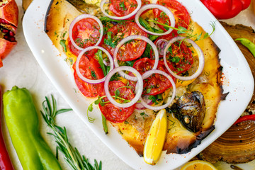 hot smoked fish koktal, Kazakh dish, with vegetables, tomatoes and onions on a festive table, special dish