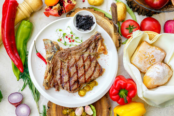 steak entrecote with pickled onions and jalapeno pepper on a white plate
