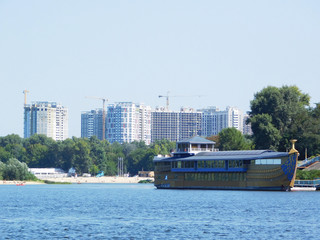 Fototapeta premium A floating restaurant on Dnipro river against the backdrop of buildings construction in Kyiv, Ukraine.