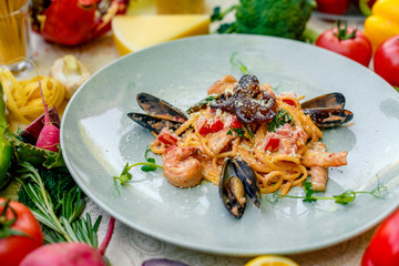 Pasta with seafood, octopus, shrimps and mussels on a decorated table