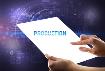 Hand holdig futuristic tablet with PRODUCTION inscription, new technology concept