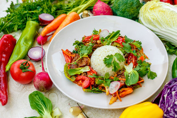 Thai meat with vegetables on a decorated table in a white plate