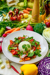 Thai meat with vegetables on a decorated table in a white plate