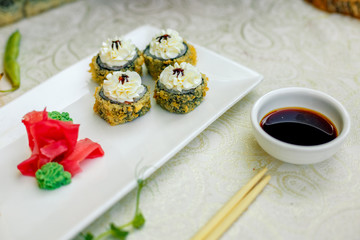 fried warm sushi with wasabi and soy sauce with chopsticks