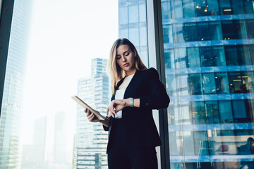 Confident caucasian female manager checking notification on wearable smartwatch with touchscreen...