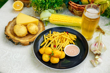 Cheese balls with crispy fresh French fries with sauce on a decorated table