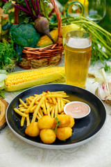 Cheese balls with crispy fresh French fries with sauce on a decorated table