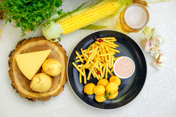 Cheese balls with crispy fresh French fries with sauce on a decorated table