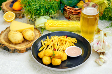 Cheese balls with crispy fresh French fries with sauce on a decorated table