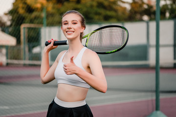 happy tennis player showing thumbs up on court