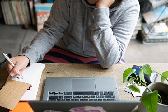 Anonymous teenager gets distracted at home while doing homework
