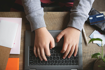Close up of teenager hands using a laptop keyboard