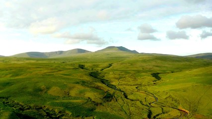 An aerian view of a volcanic plain with cloudy sky