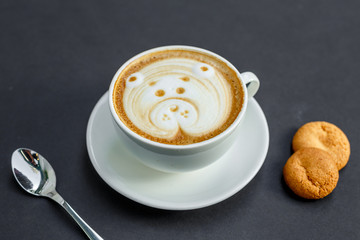 a cup of coffee with a pattern and cookies