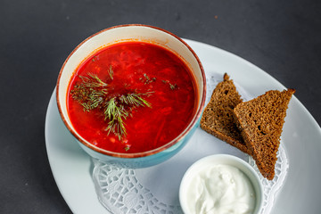 Russian dish borsch with rye bread and sour cream