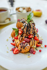 Krekembush - an elegant French profiterole cake topped with chocolate and nuts