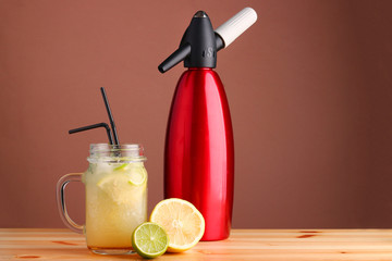 lime and lemon cocktail. non alcoholic citrus summer drinks with citrus on wooden table. Siphon, a device for making soda.