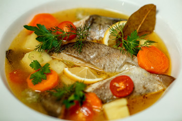 Russian soup with fish in a plate and ingredients served on the table