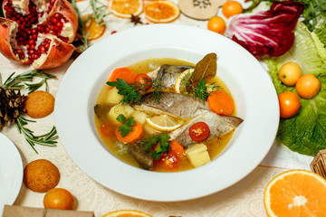 Russian soup with fish in a plate and ingredients served on the table