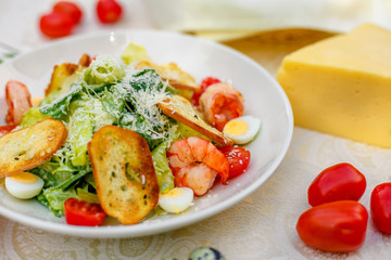 Caesar salad with seafood vegetables and herbs, healthy food on the table