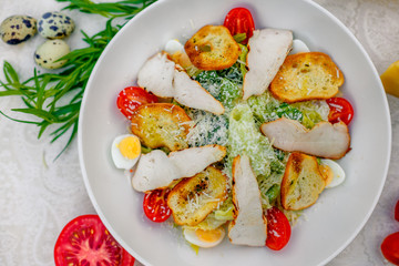 Caesar salad with chicken vegetables and herbs, healthy food on the table
