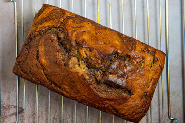 Freshly baked loaf of banana chocolate bread on cooling rack