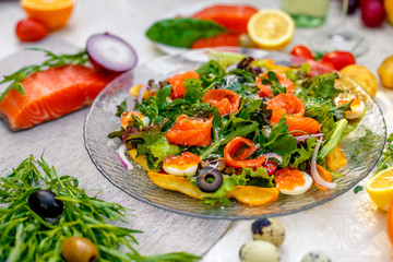 fresh salad with vegetables, greens and red fish with caviar served on the table, healthy food