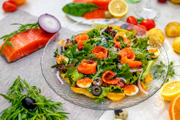 fresh salad with vegetables, greens and red fish with caviar served on the table, healthy food