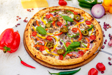 Delicious italian pizza served on table with ingredients cheese and vegetables