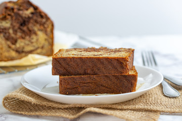 Freshly baked slices of banana chocolate bread on white plate