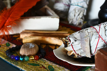 A close up image of a burning white sage smudge stick and reiki healing symbol. 