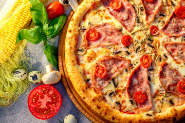Delicious italian pizza served on table with ingredients cheese and vegetables