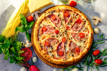Delicious italian pizza served on table with ingredients cheese and vegetables