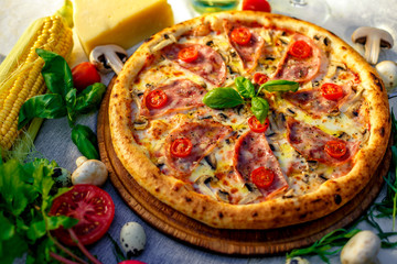 Delicious italian pizza served on table with ingredients cheese and vegetables