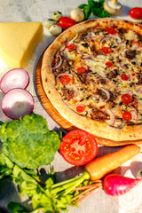 Delicious italian pizza served on table with ingredients cheese and vegetables