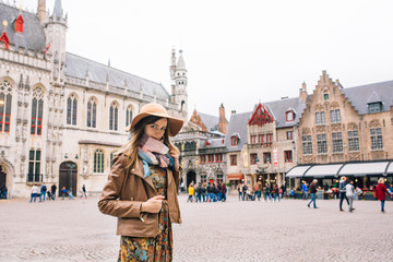 Obraz premium a girl looks at a historic building in Bruges
