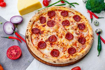 Delicious italian pizza served on table with ingredients cheese and vegetables