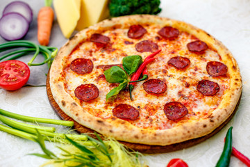 Delicious italian pizza served on table with ingredients cheese and vegetables