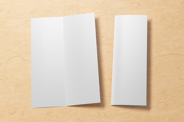 Blank vertical A4 leaflet on wooden background. Bi-fold or half-fold opened and folded brochure isolated with clipping path. Side view. 3d illustration