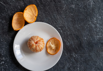 Peeled clementine on a white plate