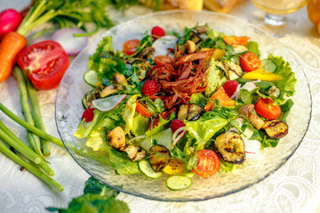 Fresh salad with dried meat, herbs and vegetables served on the table with the ingredients, healthy food