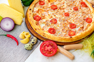 Delicious italian pizza served on table with ingredients cheese and vegetables