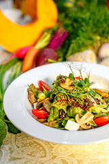 Fresh salad with mushrooms, cheese, tomatoes, herbs and vegetables served on the table with the ingredients, healthy food