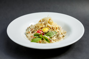 macaroni with mushrooms and cheese, with quail egg and tomato in cream sauce, isolated