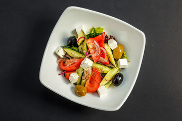 fresh greek salad with tomatoes, feta cheese, onions, olives and cucumbers, healthy food, isolated