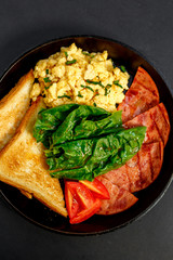 delicious omelet with bacon greens and toast in a pan, breakfast