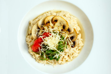 rice porridge with mushrooms, parmesan cheese, arugula and tomatoes
